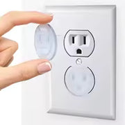 Hand pressing a motion sensor switch on a wall outlet cover