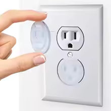 Hand pressing a motion sensor switch on a wall outlet cover
